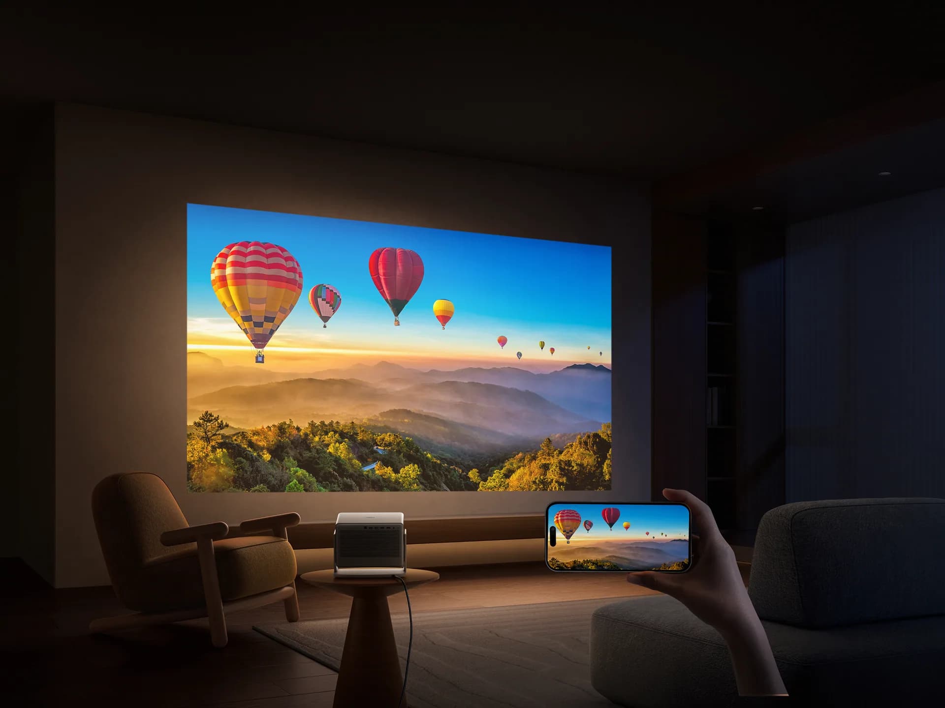 거실 벽에 투사된 열기구 풍경 4K 화면과 휴대폰으로 화면을 전송하는 손